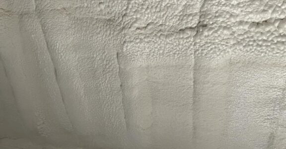 Gros plan d'un mur blanc texturé avec flocage incendie.