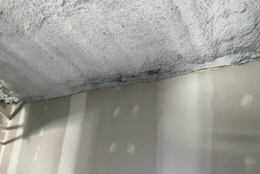 Mur partiellement fini avec plaques de plâtre visibles.