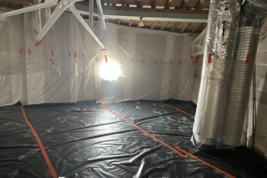 Une pièce en construction avec des bâches et de la lumière naturelle à gauche.