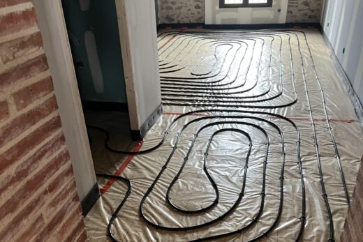 Pièce rénovée avec tuyaux de chauffage au sol en serpentin.