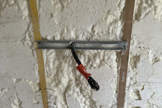 Mur de mousse pulvérisée avec un support métallique câblé.