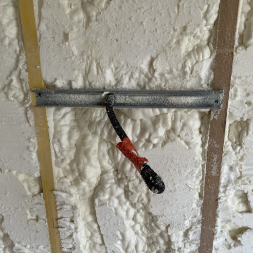 Mur de mousse pulvérisée avec un support métallique câblé.