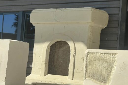 Un foyer extérieur inachevé se tient près d’une fenêtre.