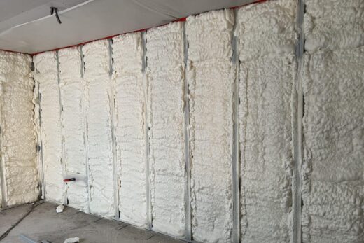 Un chantier avec isolation mousse et montants métalliques.