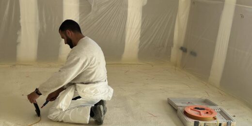Personne agenouillée, travaux d'isolation des sols.