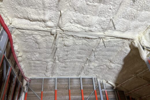 Plafond avec mousse isolante, tuyaux visibles.
