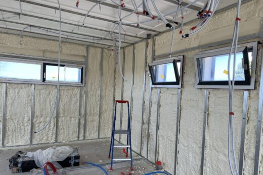 Chambre en construction : trois fenêtres, échelle rouge.