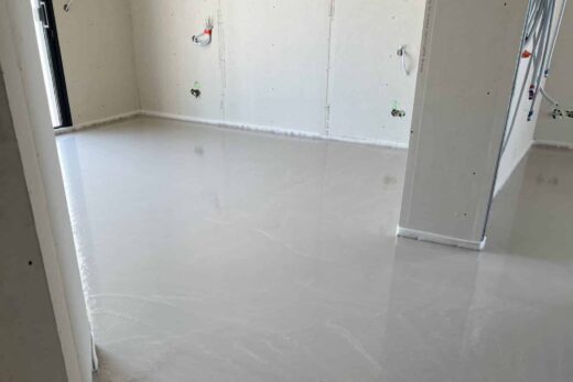 Chambre avec nouveau sol en béton et prises.