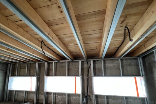 Construction : poutres apparentes, murs métalliques, fils de suspension.