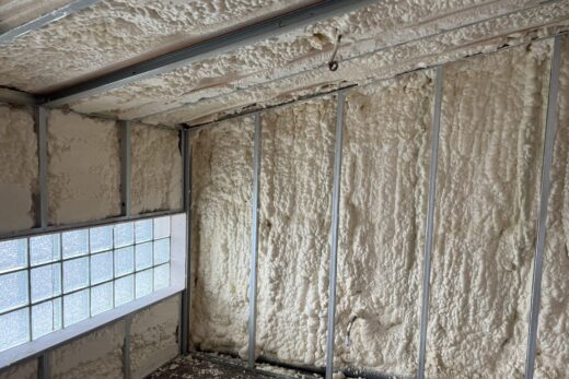 Salle en travaux, murs métalliques et fenêtres.