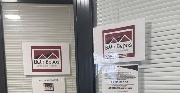 Fenêtre de bureau avec panneaux de certification "Bâtir Bepos".