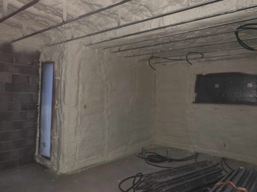Pièce en construction avec isolation, câblage et fenêtre.